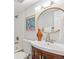Bathroom featuring vanity with wooden cabinet, framed poster and white tiled tub and shower at 4142 Chase St, Denver, CO 80212