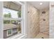 Updated shower with marble tiling, modern fixtures, and natural light from window at 4142 Chase St, Denver, CO 80212