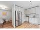 Well-lit kitchen with white cabinets, stainless steel appliances, and convenient access to the dining area at 4142 Chase St, Denver, CO 80212