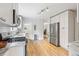 Bright kitchen features white cabinets, stainless appliances, and wood floors with open concept layout at 4142 Chase St, Denver, CO 80212