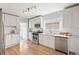 Bright kitchen features white cabinets, stainless appliances, subway tile backsplash, and wood floors at 4142 Chase St, Denver, CO 80212
