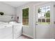 Laundry room features modern washer and dryer with a window to the fenced yard at 4142 Chase St, Denver, CO 80212