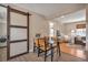 Dining area with rustic barn door and views into the living room and bedroom at 5108 S Pennsylvania St, Littleton, CO 80121