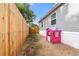 This quaint backyard features a wooden fence, home and a darling pink playhouse at 811 Plum N Ave, Lochbuie, CO 80603