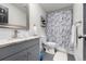 This bathroom includes a grey vanity, matching toilet, a shower and modern mirror at 811 Plum N Ave, Lochbuie, CO 80603