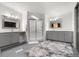 This spacious bathroom features dual vanities, a step-in shower and a large fluffy rug at 811 Plum N Ave, Lochbuie, CO 80603