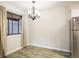 Dining area with modern chandelier, window with curtains, and new floors at 8770 Corona St # 101, Denver, CO 80229