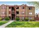 Exterior view of a tan apartment building with red trim, showcasing its well-maintained facade at 8770 Corona St # 101, Denver, CO 80229