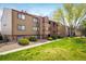 Condominium complex with lush landscaping, mature trees, and grass lawns at 8770 Corona St # 101, Denver, CO 80229