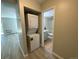 Hallway with stacked washer and dryer, leads into a full bathroom at 2160 S Vaughn Way # 104C, Aurora, CO 80014