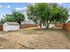 Large backyard with a storage shed and a charming additional building, surrounded by a wooden fence at 1301 Kenton St, Aurora, CO 80010