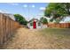 Backyard featuring a small, charming building with a red door and a white picket fence at 1301 Kenton St, Aurora, CO 80010