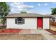 Inviting white home with a vibrant red door and manicured landscaping at 1301 Kenton St, Aurora, CO 80010