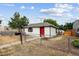 Quaint white home with a red door, fenced yard, and mailbox at 1301 Kenton St, Aurora, CO 80010
