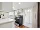 Modern kitchen with white cabinets, quartz countertops, and stainless steel appliances at 1301 Kenton St, Aurora, CO 80010