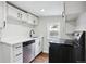 Modern kitchen features white cabinets, stainless steel appliances, quartz countertops, and stylish black hardware at 1301 Kenton St, Aurora, CO 80010