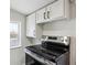 Kitchen featuring a stainless steel oven, white cabinets and countertops, and natural light at 1301 Kenton St, Aurora, CO 80010