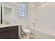 Bright bathroom featuring a shower-over-bath, a modern vanity, and a window offering natural light at 576 Nightsky St, Erie, CO 80516