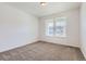 A bright bedroom with carpeted floors and a large window providing natural light at 576 Nightsky St, Erie, CO 80516