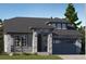 Charming single-story home with a stone facade, covered porch, and a two-car garage, exuding curb appeal at 576 Nightsky St, Erie, CO 80516