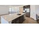 A modern kitchen is showcased with an island, stainless steel appliances, and sleek white countertops at 576 Nightsky St, Erie, CO 80516