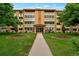 Attractive building featuring manicured lawns, mature trees, and a welcoming entrance at 625 Alton Way at 625 S Alton Way # 3A, Denver, CO 80247