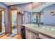 Bathroom showcasing a modern sink, large mirror with lights, and a view into the shower at 5362 S Danube Ct, Centennial, CO 80015