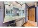 Charming bathroom featuring a rustic vanity, lighted mirrors, and wood flooring at 5362 S Danube Ct, Centennial, CO 80015