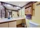 Bathroom featuring a single vanity, large mirror, quirky decor, and a toilet at 5362 S Danube Ct, Centennial, CO 80015