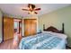Bedroom with a ceiling fan, wood-look floors, and access to the en suite bathroom at 5362 S Danube Ct, Centennial, CO 80015