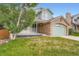 Well-maintained two-story home with charming porch and stone-accented garage, set on a green lawn at 5362 S Danube Ct, Centennial, CO 80015