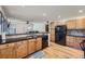Charming kitchen with wood cabinets, black appliances, and backsplash, open to the living room at 5362 S Danube Ct, Centennial, CO 80015