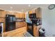Charming kitchen featuring wood cabinets, black appliances, tile backsplash, and hardwood floors at 5362 S Danube Ct, Centennial, CO 80015