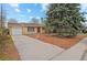 Inviting single-story brick home featuring a large driveway and mature landscaping at 3117 Victor St, Aurora, CO 80011