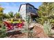 Outdoor fire pit with Adirondack chairs on a stone patio adjacent to a home with a wooden deck at 1519 Stonehill Ct, Castle Rock, CO 80104