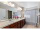 This Primary bathroom features a dual sink vanity, large mirror, and shower with striped curtain at 1519 Stonehill Ct, Castle Rock, CO 80104