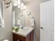 Bright bathroom features a wooden vanity, white countertops, and a large mirror at 1519 Stonehill Ct, Castle Rock, CO 80104