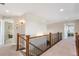 A bright hallway with wood and iron railing and two bedrooms visible at the end at 1519 Stonehill Ct, Castle Rock, CO 80104
