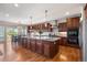 Gourmet kitchen with a large island, dark wood cabinets, and view of the deck and dining area at 1519 Stonehill Ct, Castle Rock, CO 80104