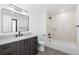 Bathroom with modern vanity, and a tub and shower combination with neutral toned tile surround at 1544 S Fillmore St, Denver, CO 80210