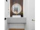 Modern bathroom with a round mirror, floating sink, and gold hardware at 1544 S Fillmore St, Denver, CO 80210