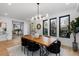 Modern dining room with a wood table, black chairs, modern lighting, and natural light at 1544 S Fillmore St, Denver, CO 80210