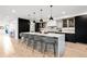 Modern kitchen with a large island, quartz countertop, modern stools, and cabinetry for storage at 1544 S Fillmore St, Denver, CO 80210
