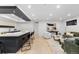 Open-concept living space features a bar-style island, modern seating, and sleek hardwood flooring at 1544 S Fillmore St, Denver, CO 80210