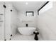 Spa-like bathroom with marble tile, stand alone tub, and black fixtures at 1544 S Fillmore St, Denver, CO 80210