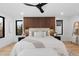 Spacious main bedroom featuring a wood-accent wall, ceiling fan, and light hardwood floors at 1544 S Fillmore St, Denver, CO 80210