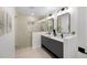Bright bathroom featuring double sinks, modern fixtures, and a glass-enclosed shower with tiled walls at 2849 N Vine St, Denver, CO 80205
