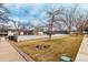 Well-kept community green space with manicured lawn and mature trees near townhomes and a sidewalk at 5865 E Ithaca Pl, Denver, CO 80237