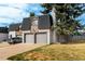 Townhome with brick and stone details, a two-car garage, and a nicely landscaped lawn in a residential neighborhood at 5865 E Ithaca Pl, Denver, CO 80237