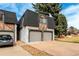 Townhome exterior featuring stone accents, a two-car garage, and a well-kept driveway in a residential area at 5865 E Ithaca Pl, Denver, CO 80237